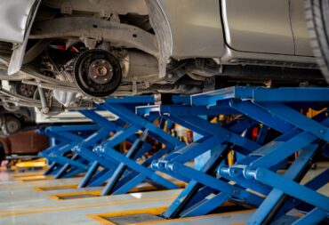 Car disc brake system and suspension maintenance during tire replacement at a garage workshop. Automotive repair and professional mechanic services for vehicle safety and performance optimization. Car disc brake system and suspension maintenance during tire replacement at a garage workshop. Automotive repair and professional mechanic services for vehicle safety and performance optimization.